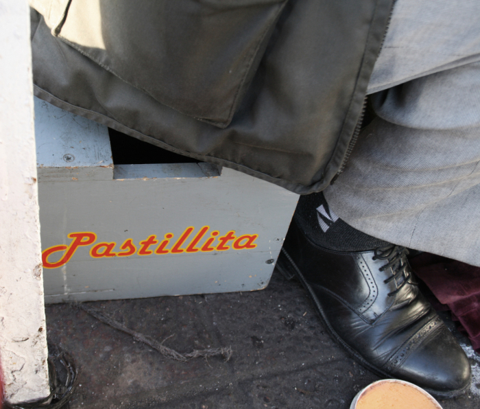 “EL Pastillita” is written on the box on which he is sitting