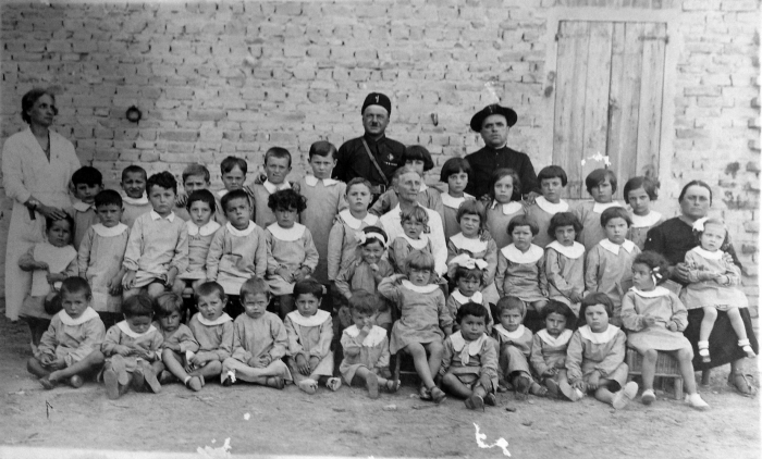 Il podestà, il prete, la perpetua e la maestra. Asilo e scuola elementare di bambini e bambine di età miste nel comune di Canossa, Reggio Emilia. Nel febbraio 1929 i maestri elementari vennero obbligati al giuramento: “Giuro che sarò fedele al re e ai suoi reali successori; che osserverò lealmente lo statuto e le altre leggi dello Stato; che non appartengo e non apparterrò ad associazioni o partiti, che adempirò ai doveri stessi con diligenza e con zelo, ispirando la mia azione al fine di educare i fanciulli affidatimi al rispetto della Patria e all’ossequio alle istituzioni dello Stato”. Il tutto avvenne senza alcuna resistenza.Archivio fotografico Famiglia Possentini